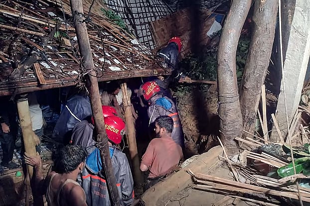 Fire Service personnel conduct rescue operations to recover casualties after landslides triggered by heavy rainfall at Rohingya refugee camps in Ukhiya, Cox's Bazar, early Monday.