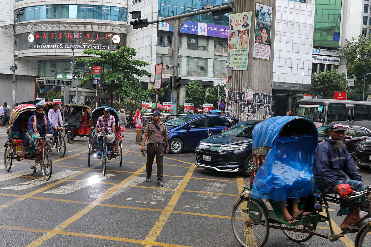 A member of the traffic police directs vehicles at the Banglamotor road.