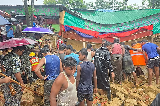 Rescuers and Rohingya volunteers search for children trapped under a collapsed wall and a mound of earth at Camp 5 in Ukhiya, Cox’s Bazar, on Wednesday afternoon.
