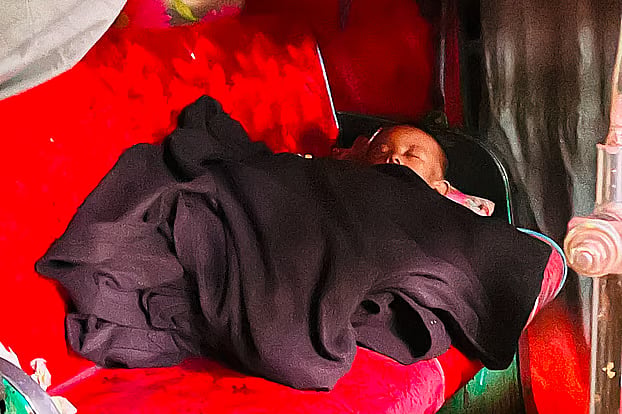 Forced to leave her flooded home, Taslima Akter has sought refuge in an auto-rickshaw parked on a culvert, where she has put her young daughter to sleep.