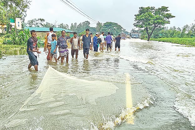 Vehicles move slowly through a flooded section of the Chattogram–Cox's Bazar highway after heavy rain and hill runoff inundated the road, causing severe disruption. Local residents fish in the submerged highway in Chandanaish, Chattogram