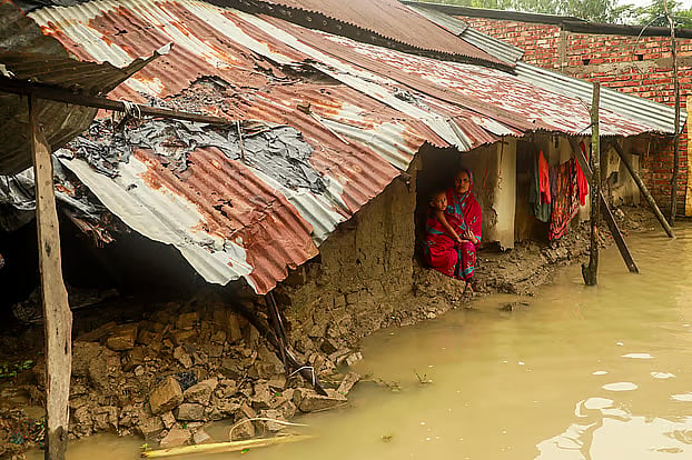 Rima Akter stands worried beside her mud house, which was destroyed by floodwaters after returning from a shelter centre. The photo was taken in Ilsha village of Baharchhara, Banshkhali, Chattogram.