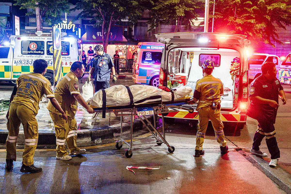 Emergency workers prepare to place the body of a victim into an ambulance after a fire at the Rong Beer Na Lat Phrao bar in Bangkok on 13 July, 2026.