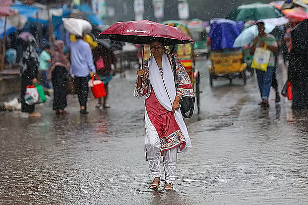 Office-goers make their way to work amid heavy rain.