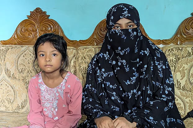 Nazmin Akter and her six-year-old daughter, Tayeba Noor, wait for Kamrul Hasan to return home. 

