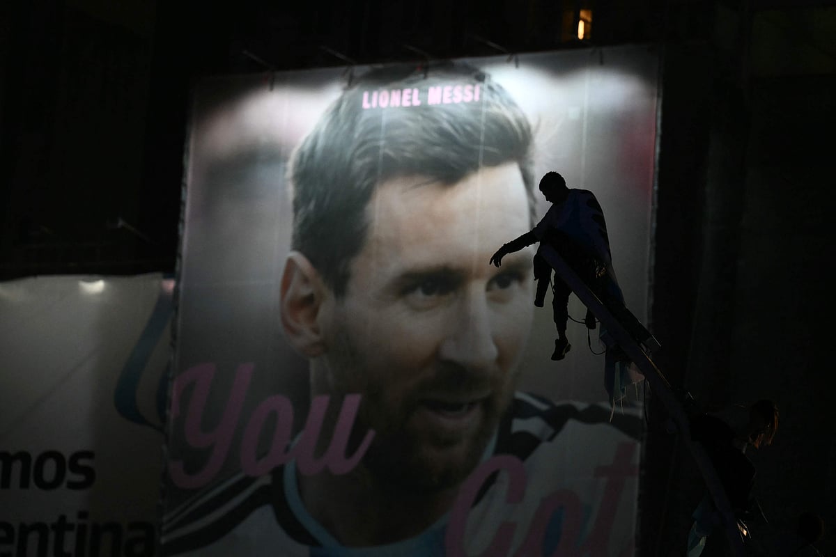 Argentina's fans are silhouetted as they stand atop a pole in front of an image of Lionel Messi near the Obelisk after Argentina lost the FIFA World Cup final football match against Spain in Buenos Aires on 19 July, 2026. Spain won by 1-0.