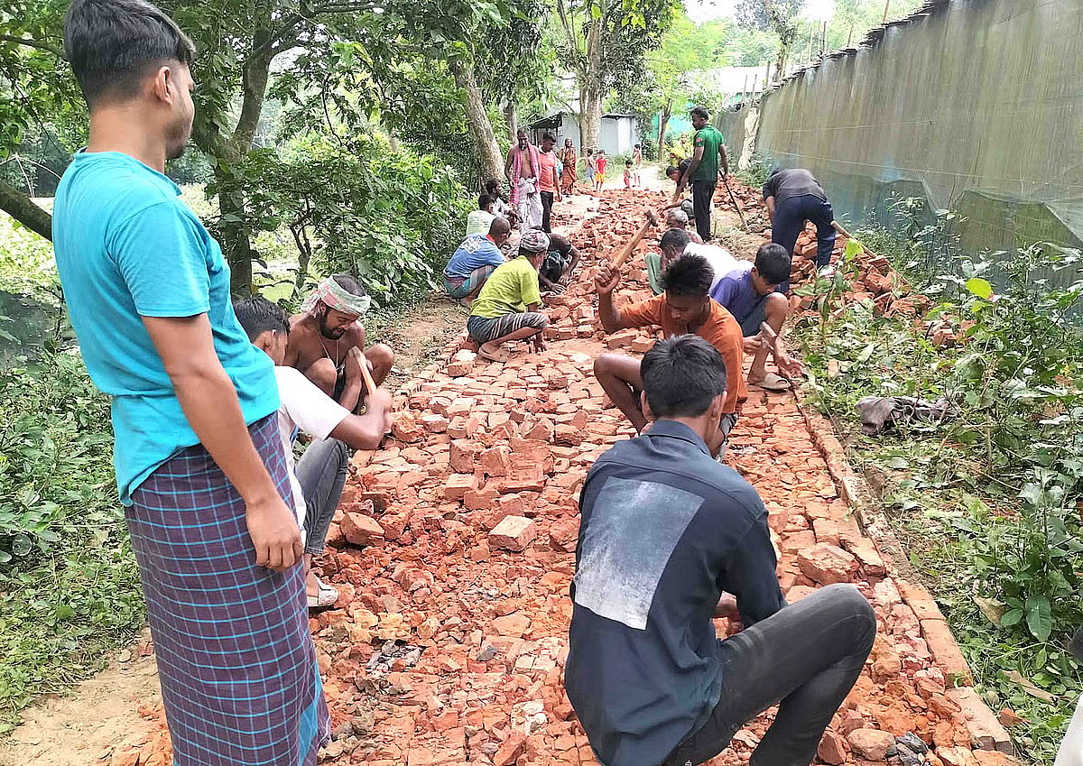 Young residents of Lalmonipur village in Natore lay bricks along the village’s earthen road through voluntary community labour. The work was carried out on 21 July 2026