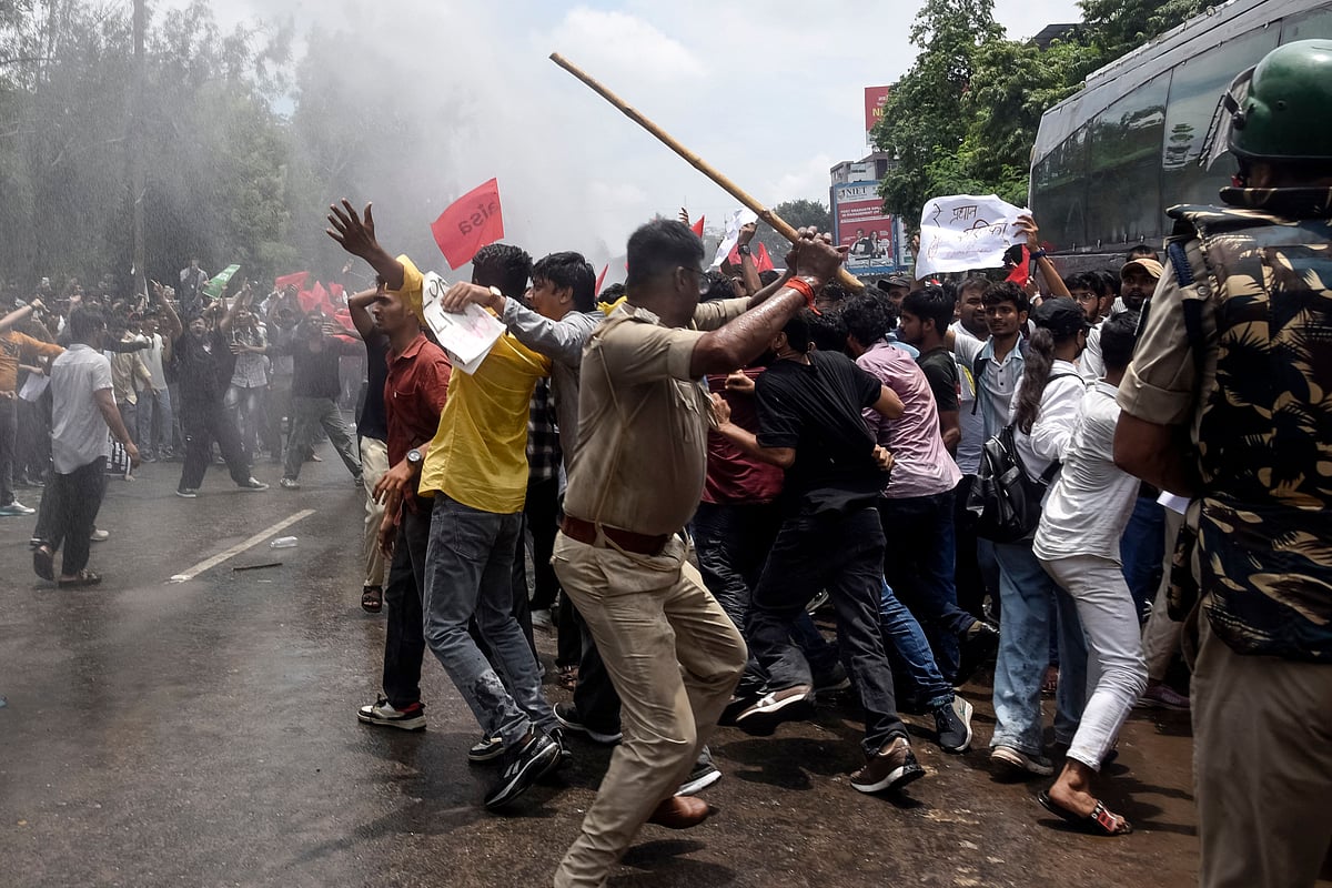 Police personnel use batons to disperse demonstrators during a protest march in Patna on 22 July 2026 demanding the resignation of India's Education Minister Dharmendra Pradhan over alleged NEET exam irregularities. The protests, led by the social media-driven Cockroach Janta Party (CJP) movement, have emerged as one of the biggest challenges to Prime Minister Narendra Modi's government since his re-election in 2024.