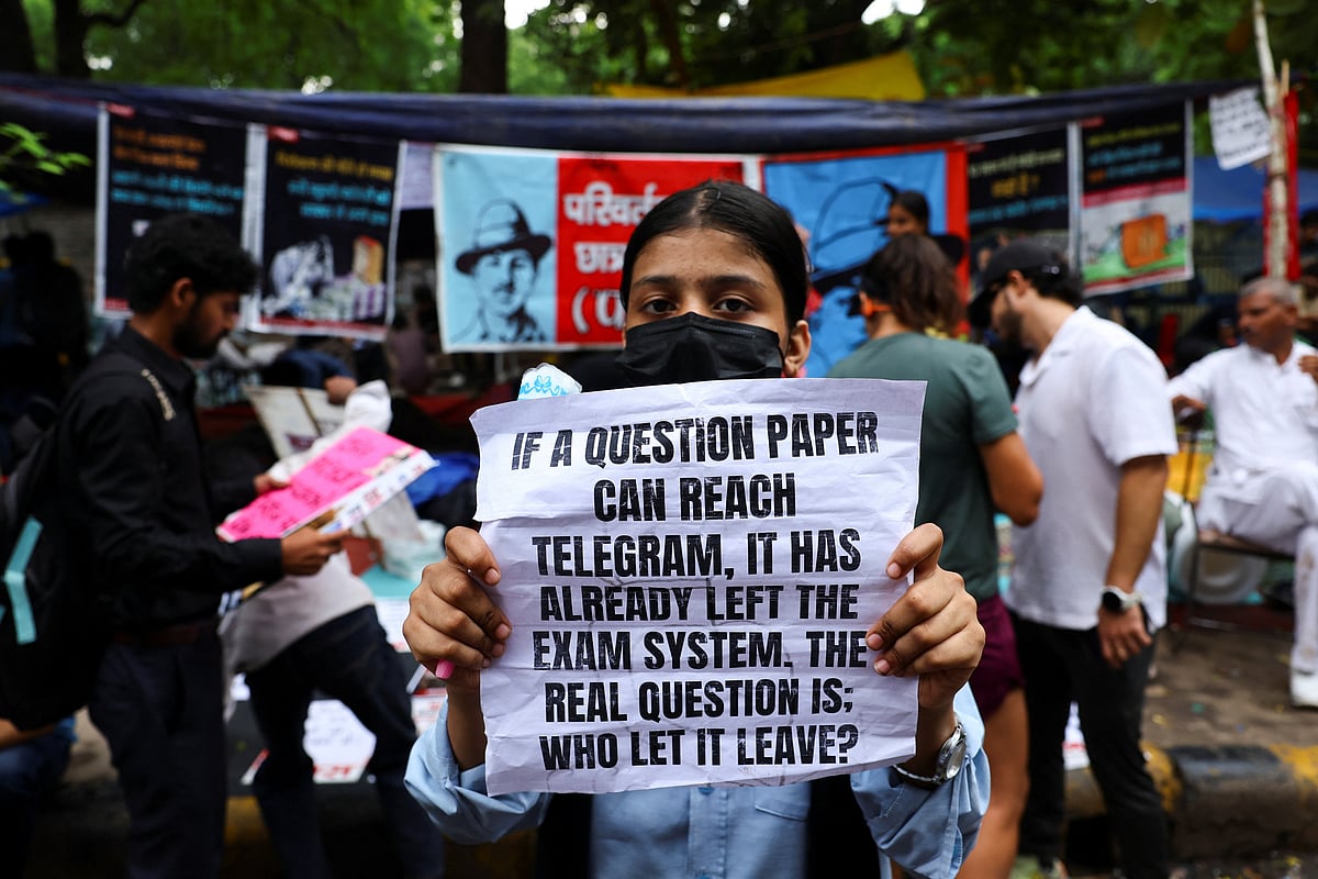 A supporter of India's Cockroach Janata Party (CJP) holds a sign during the ongoing protests, a few days after thousands of protesters marched towards parliament demanding the resignation of Education Minister Dharmendra Pradhan over National Eligibility cum Entrance Test (NEET) examination paper leaks, at Jantar Mantar in New Delhi, India, 23 July, 2026.