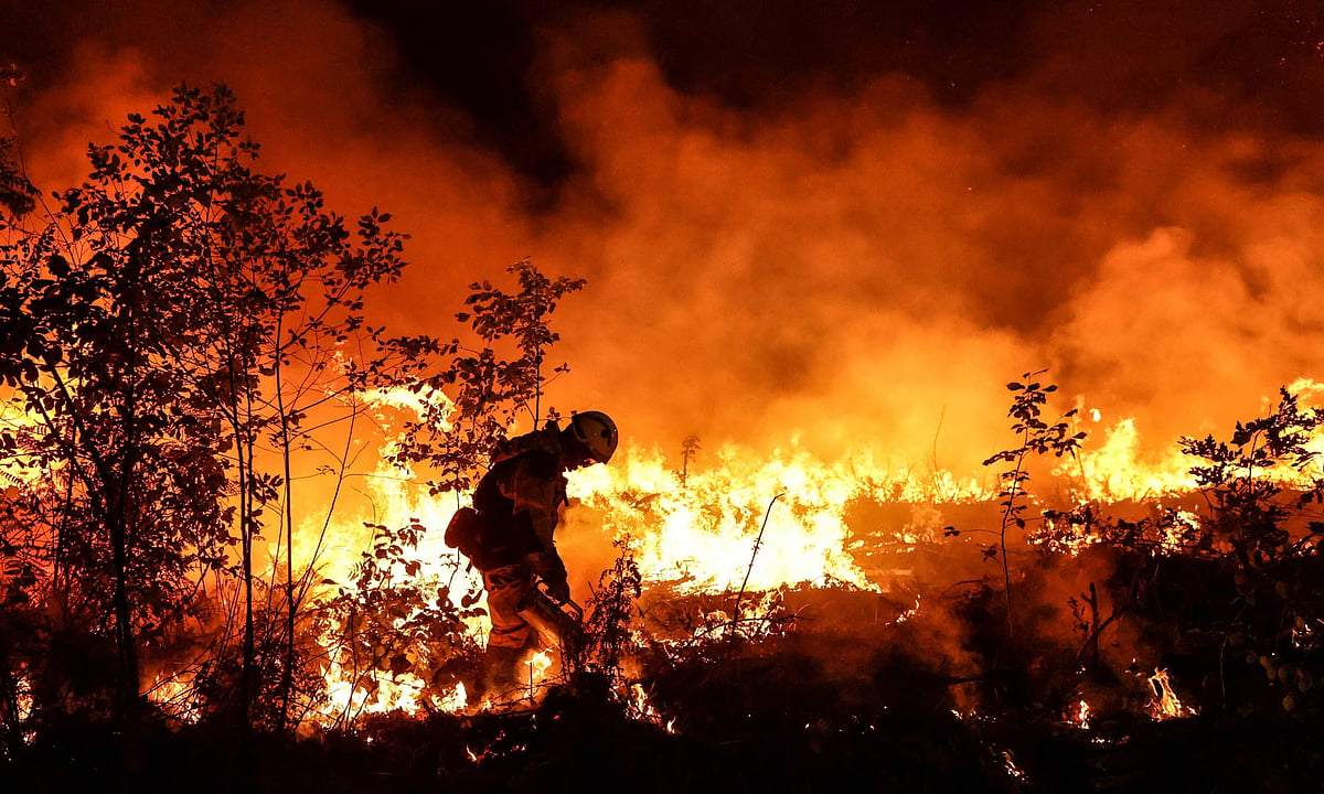 A firefighter burns a plot of land to try to stop a wildfire from spreading near Louchats in Gironde, south-west France.