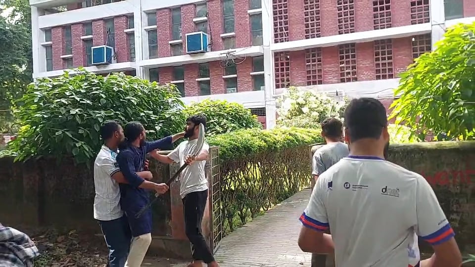 RUCSU General Secretary Salahuddin Ammar rushes toward the Rajshahi University Central Library holding a shovel on 27 July 2026