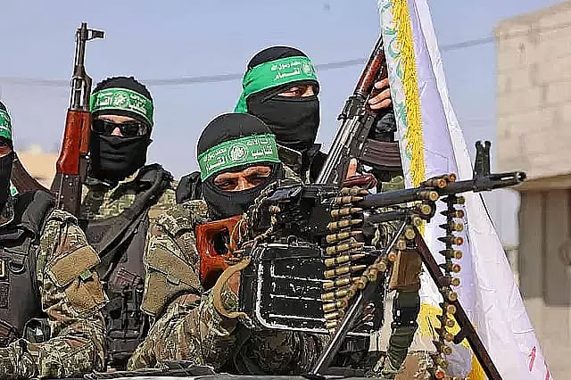 Hamas fighters carrying weapons in Gaza, Palestine.