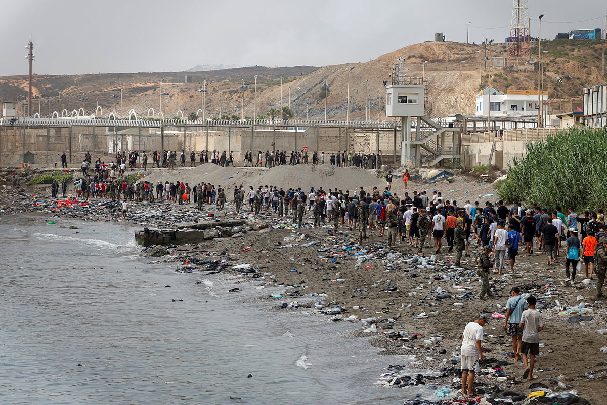 People walk towards the border with Morocco leaving Spain, amid mass crossings of migrants on foot and by sea from Morocco into Spanish territory, in Ceuta, Spain, 31 July, 2026.