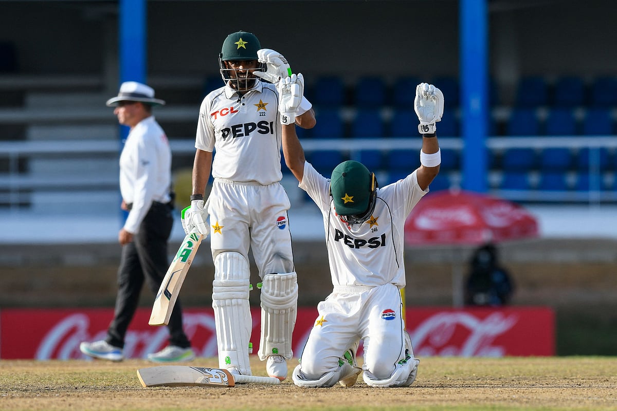 Babar Azam (L) cheers as Abdullah Shafique (R) of Pakistan celebrates his century during the second day of the second Test match between West Indies and Pakistan at Queen's Park Oval in Port of Spain, Trinidad and Tobago, on 3 August, 2026.