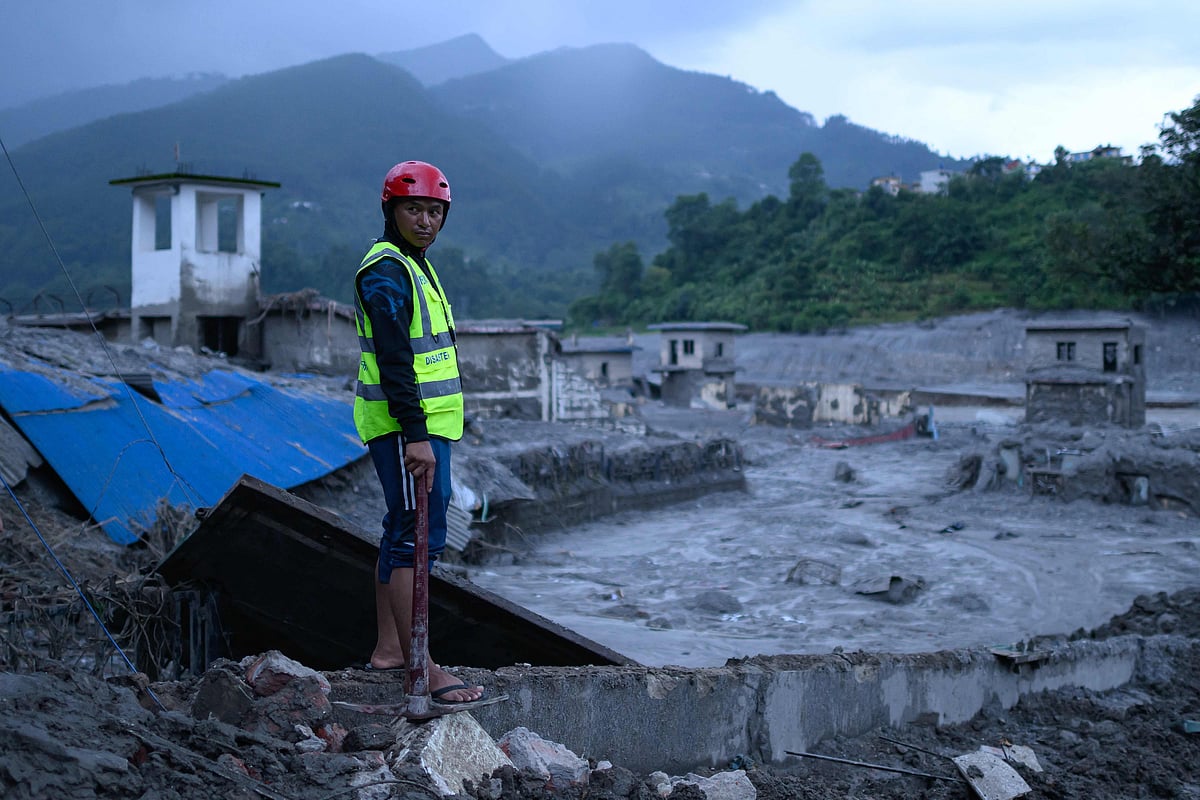 TOPSHOT - A disaster rescue personnel looks on at the site of damaged buildings in the aftermath of flash floods at Trishuli Bazar in Nepal's Nuwakot district on August 29, 2026. Devastating floods near the border with China this week have killed at least 675 people in Nepal, the Himalayan nation's disaster authority said on August 29. (Photo by MANAN VATSYAYANA / AFP)