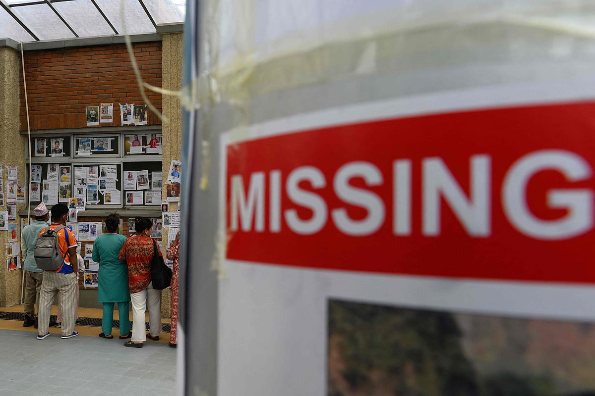 Relatives look at photographs of missing persons in the aftermath of flash floods, at the Tribhuvan University Teaching hospital in Kathmandu on 31 August 2026. Nepal was burying on 31 August some of the hundreds of bodies retrieved after a deadly, tsunami-like flood crashed through the Himalayan region, sweeping away villages and leaving thousands still missing. Distraught families have packed rescue stations and hospitals in search of their missing relatives, while others have faced the grim task of identifying bodies at overflowing morgues.