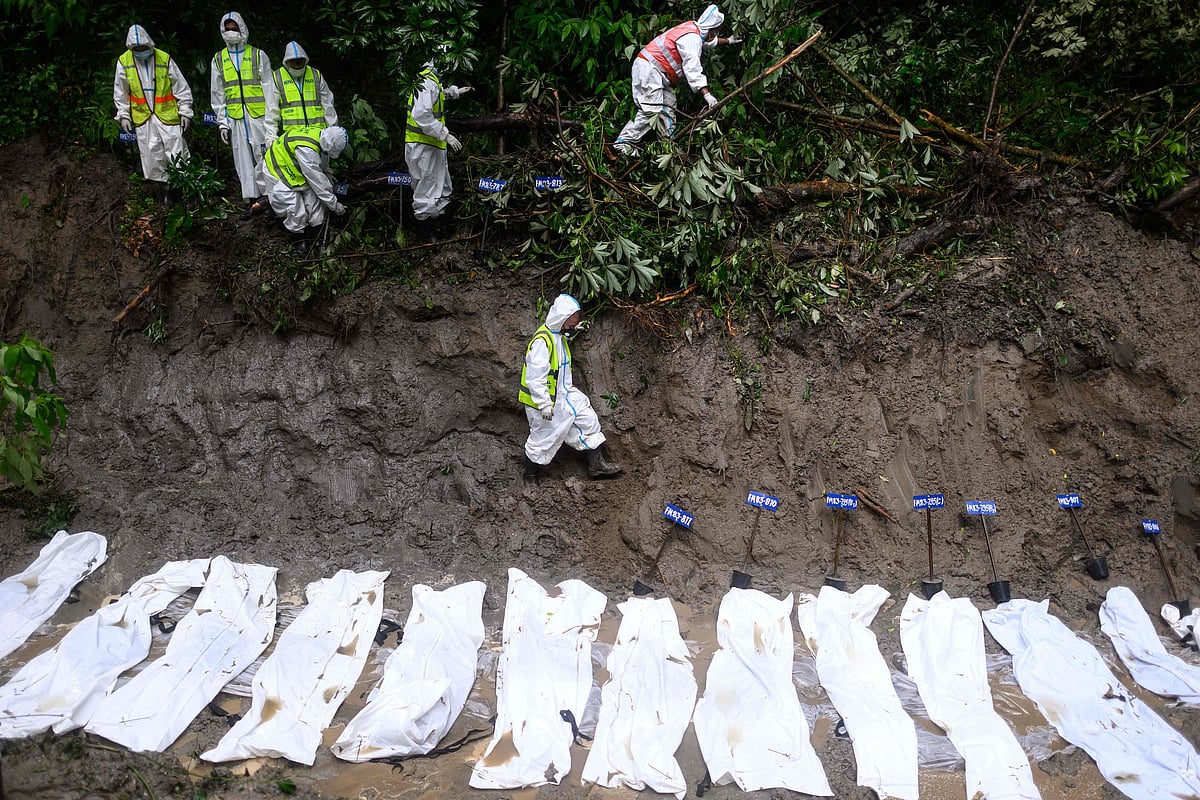 Security personnel walk past unidentified bodies of flood victims kept for mass burial inside a pit at the Gokarna forest reserve in Kathmandu on 1 September 2026