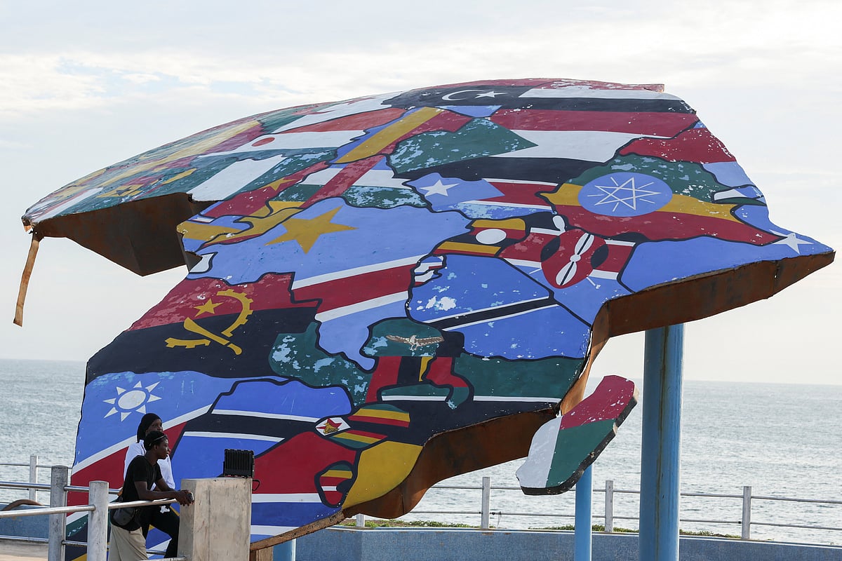 People stand beside a sculpture of the African continent, painted with the flags of African nations, at the Place du Souvenir Africain in Dakar, Senegal, 3 September 2026.