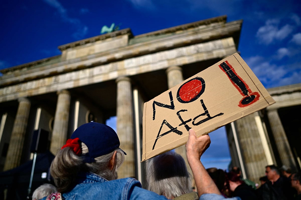 A participant displays a placard with the lettering 'No AfD' in front of the Brandenburg Gate in Berlin on 7 September 2026, during a rally under the motto 'Time to Act: Stop the AfD!', a day after the far-right Alternative for Germany (AfD) party scored its biggest win yet with 44pc of the vote in the Saxony-Anhalt state election