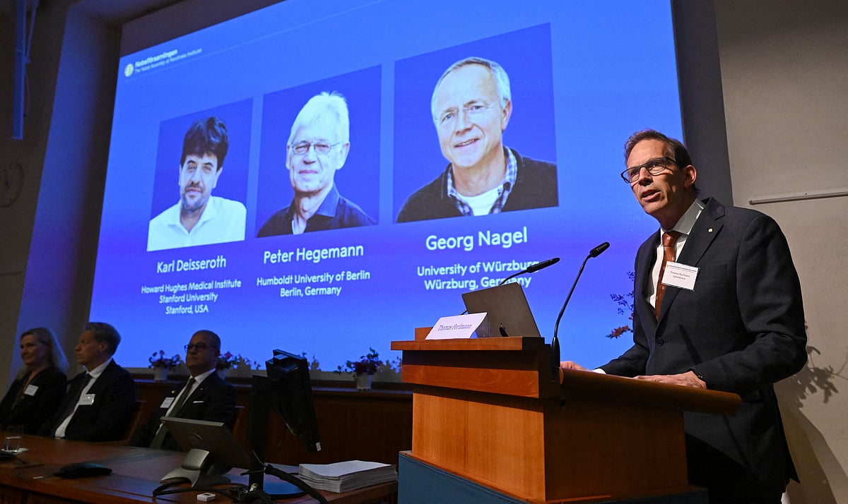 Nobel Committee Secretary General Thomas Perlmann (R) speaks to the media in front of a screen displaying the names of this year's laureates (L-R) Karl Deisseroth, Peter Hegemann and Georg Nagel during the announcement of the winners of the 2026 Nobel Prize in Physiology or Medicine at the Karolinska Institute in Stockholm, Sweden, on 5 October 2026.  
