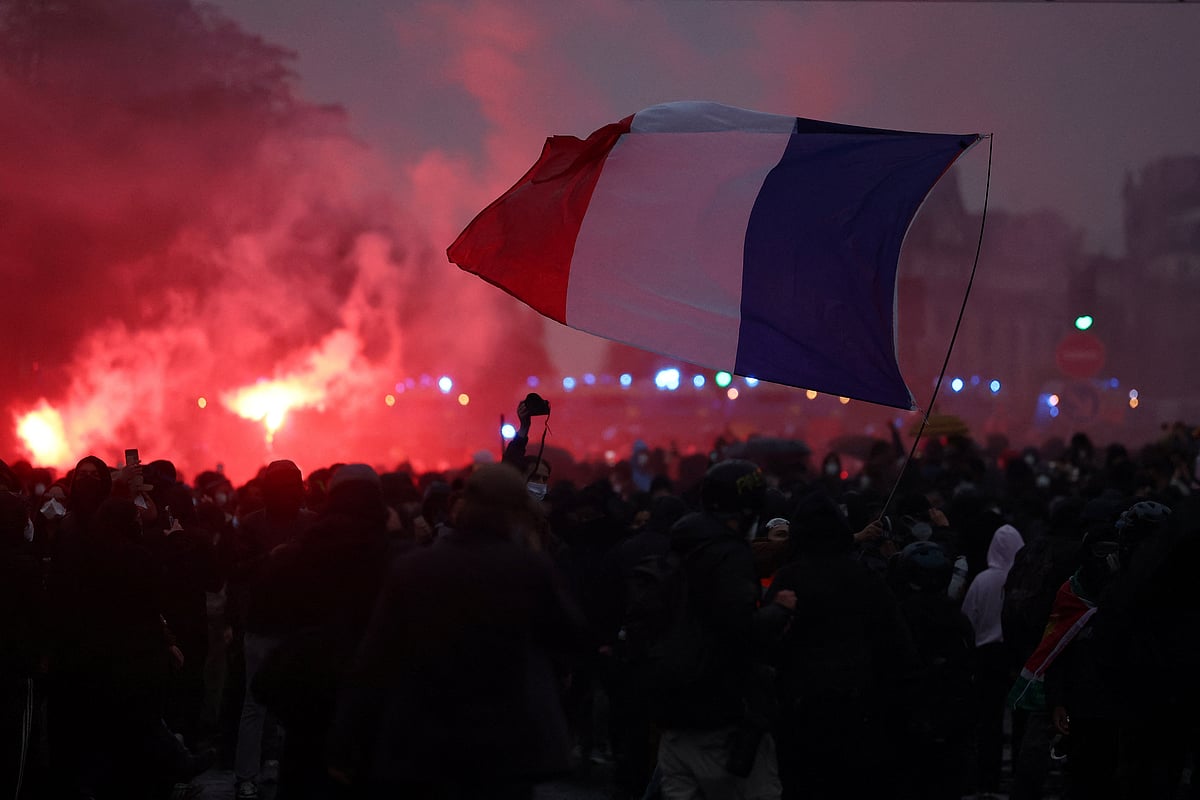 Protesters hold a French flag amid clashes during demonstration organised by labour unions in Paris as part of nationwide protests called by the "Yellow Vests" movement joined by French high school and university students against the cost of living and rising fuel prices, in France, 24 October, 2026.