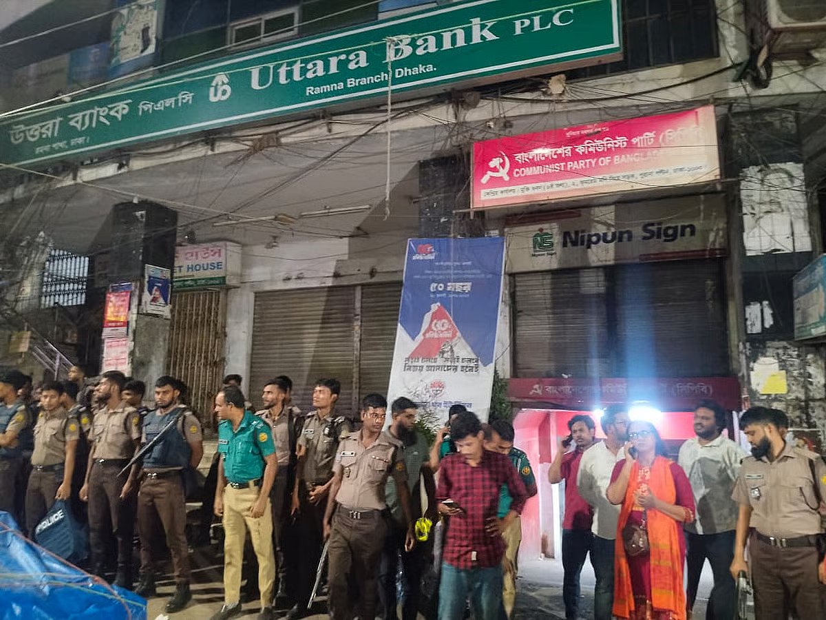 Police officers stand outside the central office of the Communist Party of Bangladesh (CPB) following an attack on Monday night.