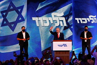 Israel's Prime Minister Benjamin Netanyahu waves to his supporters at the election night rally after the first exit polls were announced, in Jerusalem on early 28 October 2026, during Israel's legislative elections. Netanyahu vowed early on the following day to form a new government after a close election, saying no leader should rule through the backing of Israeli Arabs, whose parties posted strong gains.