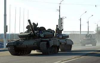 Pro-Russian separatists ride tanks in the eastern Ukrainian city of Lugansk on February 21, 2015. Ukraine's military and pro-Moscow rebels swapped scores of prisoners in rare compliance with a truce so badly breached over the past week that the US warned it could escalate sanctions on Russia within days. AFP PHOTO
