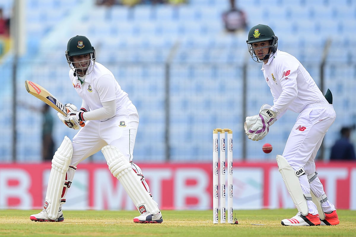 Bangladesh cricketer Shakib Al Hasan (L) plays a shot as South Africa's wicketkeeper Quinton de Kock (R) looks on during the third day of the first cricket Test match between Bangladesh and South Africa at Zahur Ahmed Chowdhury Stadium in Chittagong on 23 July, 2015