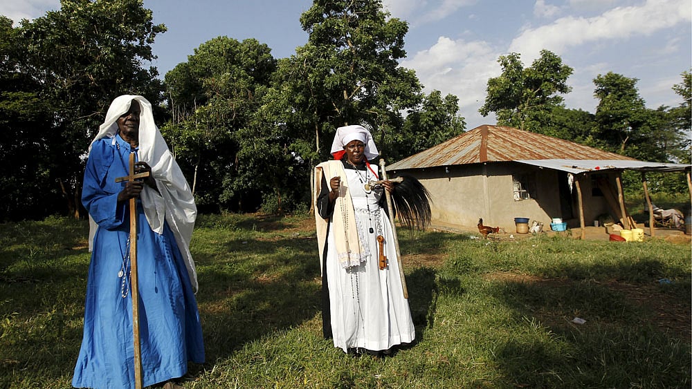 Clementina Auma Ojwang (L) and her daughter Margaret Ngesa (R) of the Legion Maria of African Church Mission pose for a photograph after praying for the State visit by U.S. President Barack Obama inside their family sacred hut in Kogelo, west of Kenya