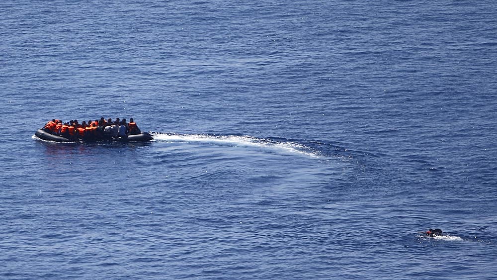 A man tries to swim towards a dinghy carrying migrants as it leaves for the Greek island of Lesbos from the southern Turkish coastal town of Behramkale in the Aegean sea between Turkey and Greece, August 27, 2015. Photo: Reuters