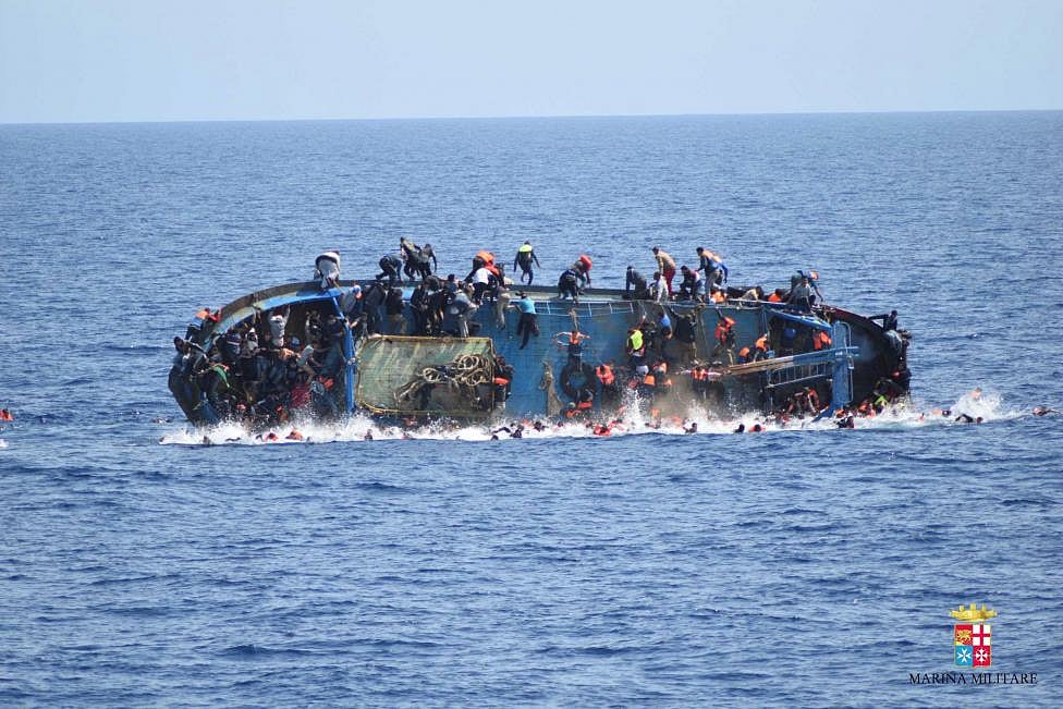 Migrants are seen on a capsizing boat