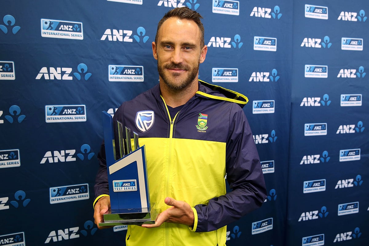 South Africa’s captain Faf du Plessis holds the trophy after the day five of the third Test cricket match between New Zealand and South Africa was called off due to rain at Seddon Park in Hamilton