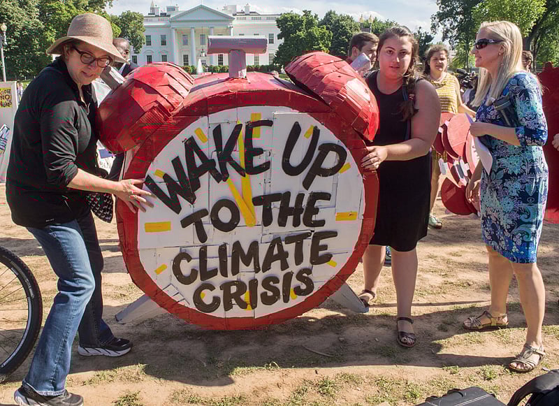 Protesters hold up signs during a demonstration in front of the White House in Washington, DC on June 1, 2017, objecting to US President Donald Trump`s decision to withdraw from the Paris Climate accord.