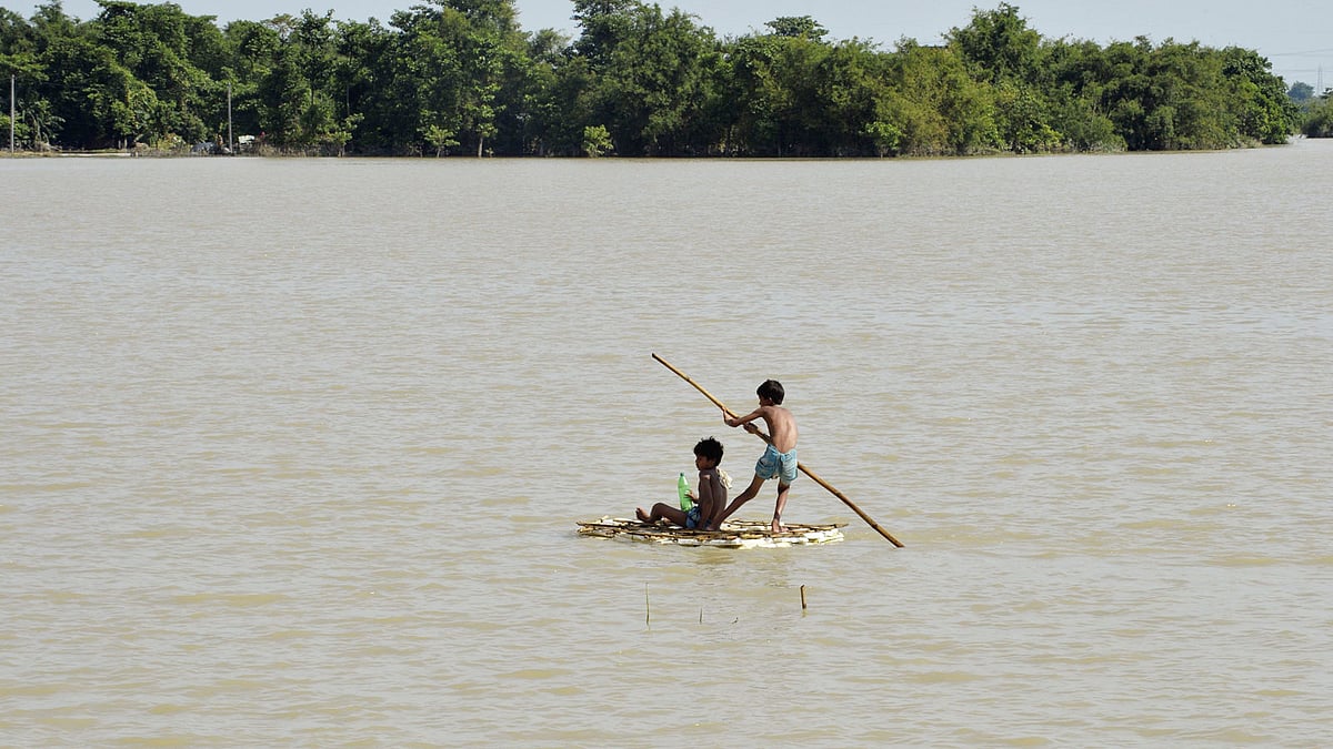 Two children on a raft made of banana plants in search of drinking water amid flood