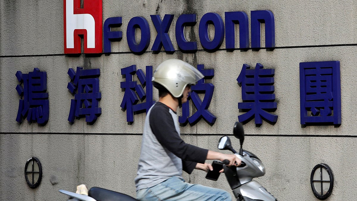 A motorcyclist rides past the logo of Foxconn, the trading name of Hon Hai Precision Industry, in Taipei, Taiwan on 30 March.