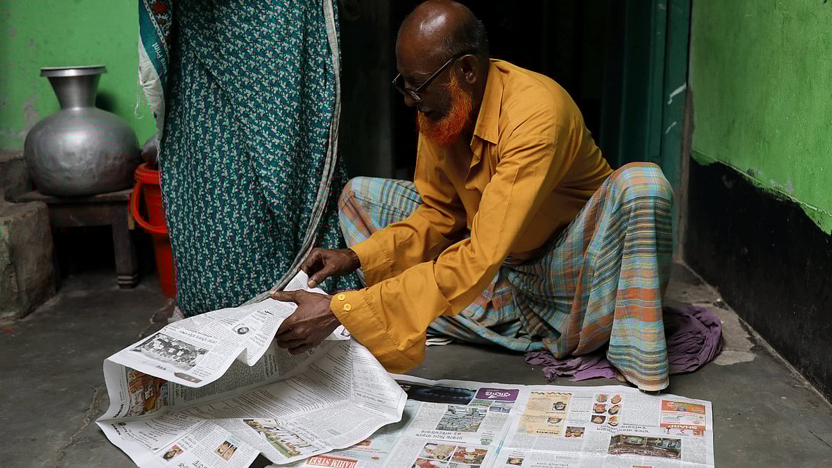 Hafiz Mia flips through the newspapers, for news of his son Riazul Islam, an alleged drug dealer who was killed by police in Tongi, Gazipur, Bangladesh, 21 July, 2018.