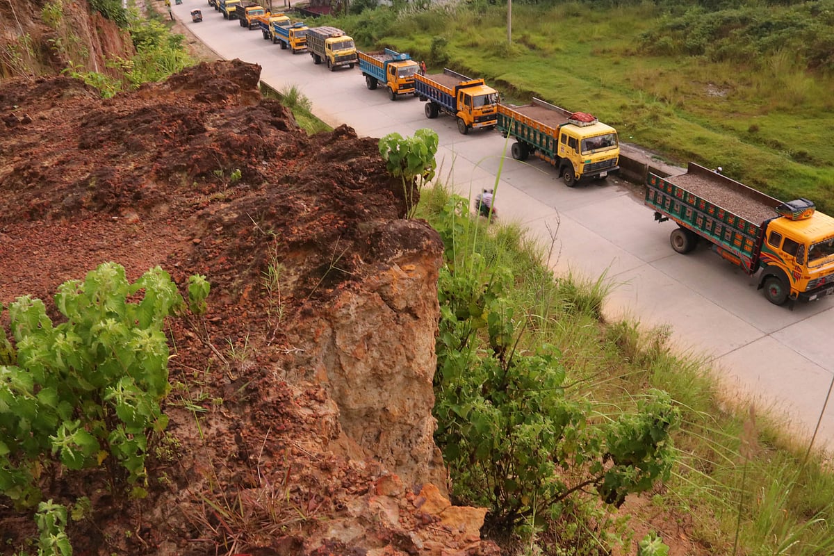 Vehicles ply by a road beside cracked hills in Barashala area of Sylhet . The hills due to landslides have caused accidents several times before.