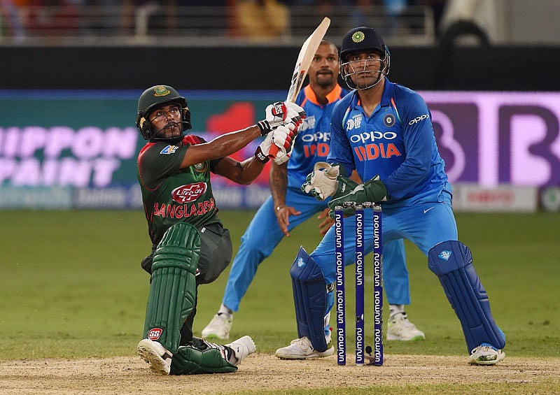 Bangladesh batsman Mehidy Hasan Miraz (L) plays a shot as as Indian wicketkeeper Mahendra Singh Dhoni (R) looks on during the one day international (ODI) Asia Cup cricket match between Bangladesh and India at the Dubai International Cricket Stadium in Dubai on September 21, 2018. AFP