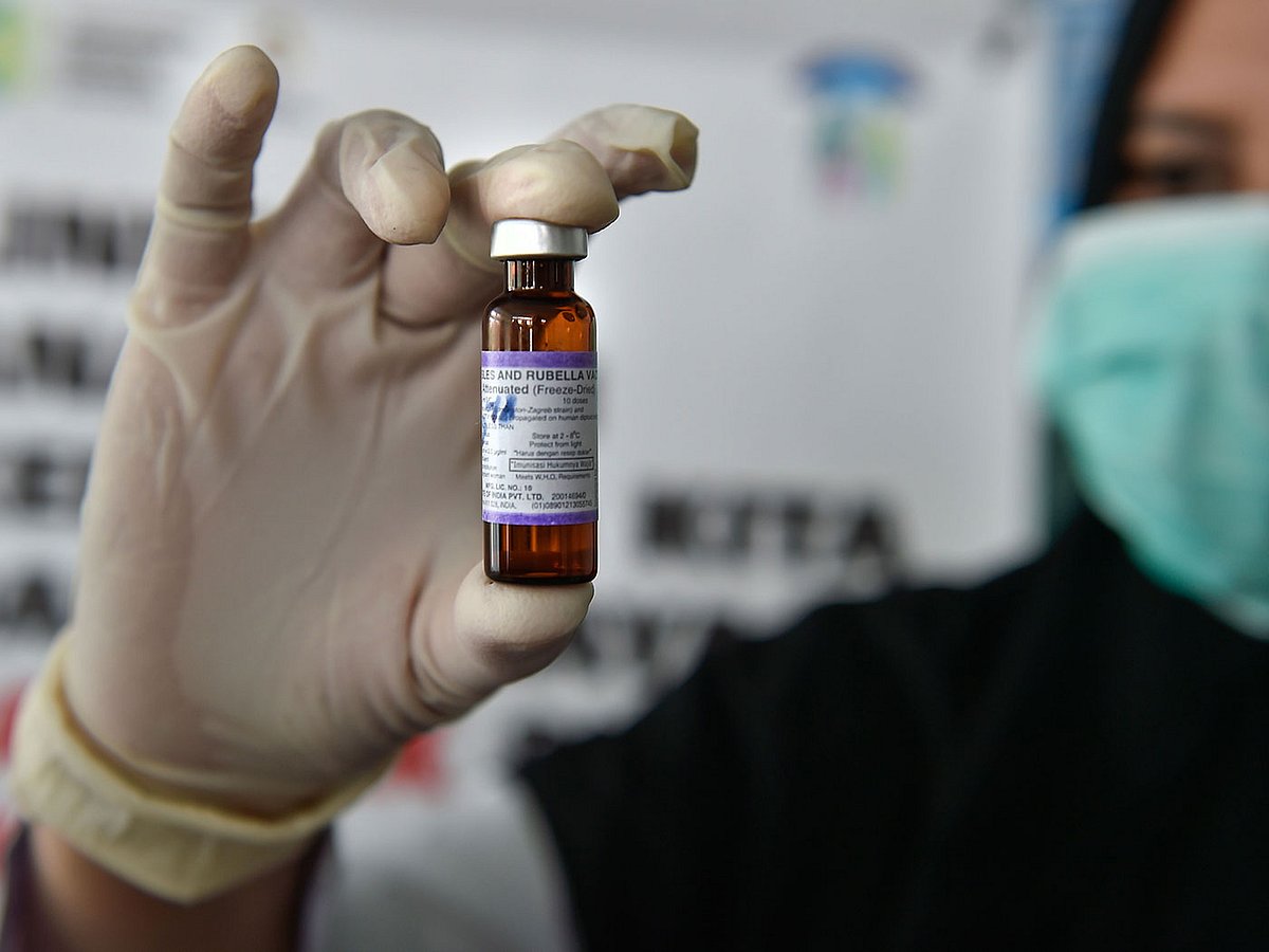 In this file photo taken on 18 September 2018 A medical worker holds a measles-rubella (MR) vaccine at a health station in Banda Aceh in Aceh province, Indonesia on 19 September 2018