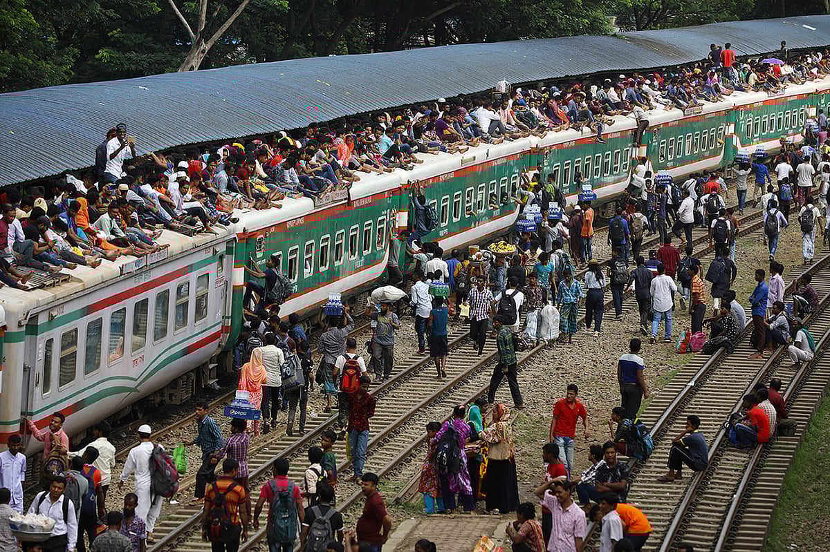 People board atop an overcrowded passenger train as they travel home to celebrate Eid al-Azha festival at a railway station in Dhaka, Bangladesh, on 10 August 2019.
