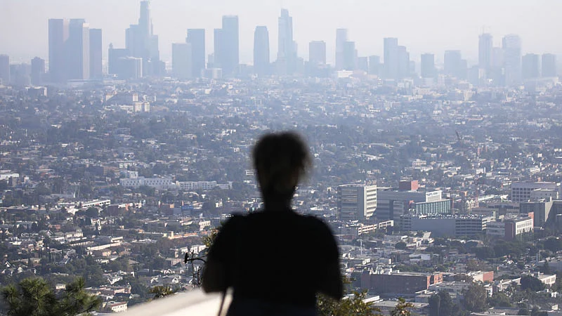 People gather at Griffith Observatory in the afternoon with downtown Los Angeles in the background on 4 November in Los Angeles, California. The air quality for metropolitan Los Angeles was predicted to be unhealthy for sensitive groups today by the South Coast Air Quality Management District.