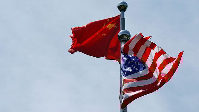 Chinese and US flags flutter near The Bund, before US trade delegation meet their Chinese counterparts