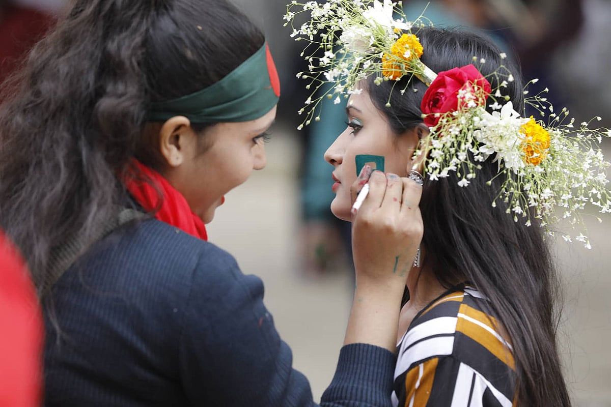 A woman paints a flag on the face of a woman during a celebration of the 49th Victory Day of Bangladesh in Dhaka on 16 December 2019.
