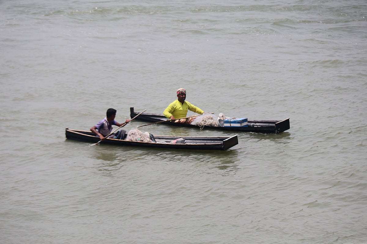 টিনের তৈরি ছোট্ট নাও নিয়ে পদ্মায় মাছ ধরতে নেমেছেন দুই মৎস্যজীবী